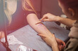 © MartaKlos - Close up temporary tattoo on arm of client which making worker. Preparation. Transfer the sketch to the body.