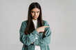 © Drobot Dean - Young displeased woman looking at camera while pointing finger aside