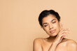 © LIGHTFIELD STUDIOS - african american young woman with closed eyes and bare shoulders isolated on beige