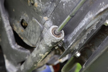 Old inboard motor boat stern drive lower unit rusty power trim and tilt cylinder after use in salt water closeup