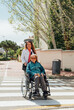 © ADDICTIVE STOCK - Aged mother in wheelchair and adult daughter walking in city