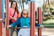 © ADDICTIVE STOCK - Woman with aged mother in wheelchair on sports ground