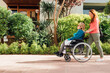 © ADDICTIVE STOCK - Woman walking with mother in wheelchair in city