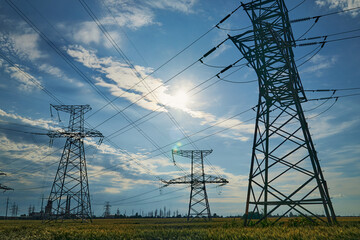 High-voltage electric lines, towers and industrial infrastructure against the blue sky