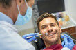 © Kostiantyn - Smiley brunette man having a dental appointment at clinic