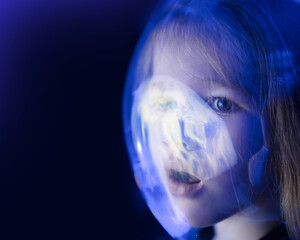 Wall Mural - girl dreams of becoming astronaut and flying into space. reflection of planet