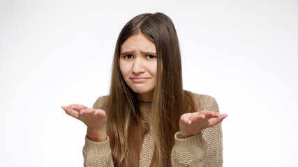 Shocked or dissapointed girl asking what is this with hand gesture over white studio background.