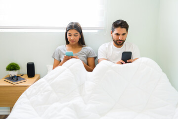 Wall Mural - Girlfriend and boyfriend using their phones in the bedroom