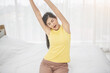 © Nitiphol - Young woman wake up in the morning and stretching on her bed