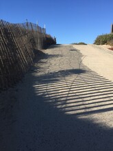 Sand Dunes And Fence At The Beach On A Sunny Day