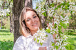 © Дарья Колпакова - Young woman stands in the park next to a flowering tree. Spring time.