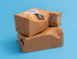 Damaged cardboard box with hole on blue background,cardboard box destroyed in shipping