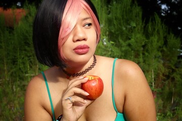 Wall Mural - Portrait of Asia woman eating red apple on hand