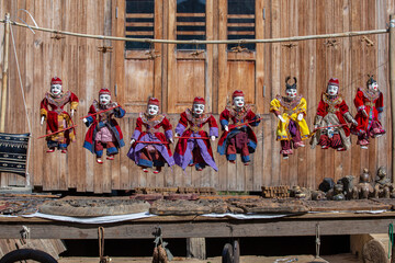 Wall Mural - Colorful puppets in a tourist stall on the street market in Burma, Myanmar. Handmade dolls hanging on display store