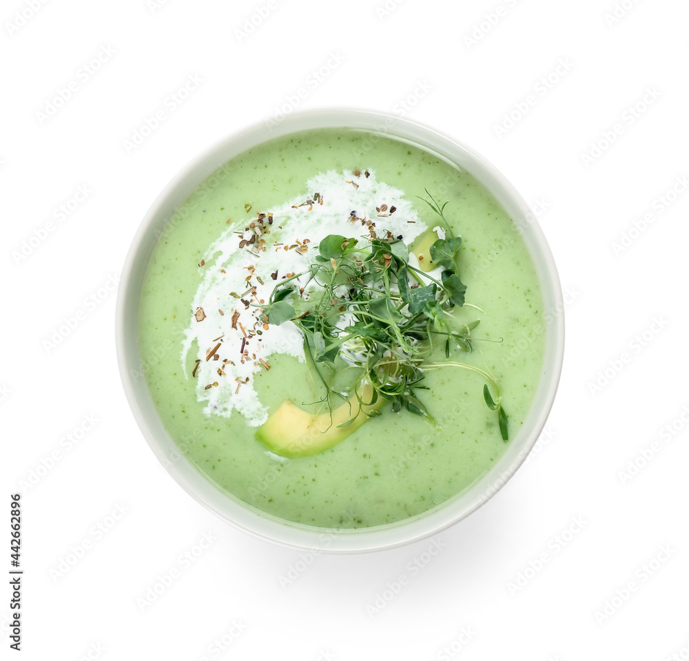 Bowl with green gazpacho on white background