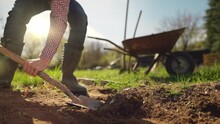 Male Farmer In Plaid Shirt And Straw Hat Is Digging In Garden With Shovel At Sunny Spring Day Shot In 4k Super Slow Motion