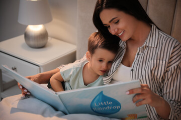 Canvas Print - Mother reading bedtime story to her son at home