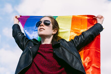 Cheerful Woman With Waving Rainbow Flag In City