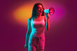 Caucasian young woman isolated on orange studio background in neon. Concept of human emotions, facial expression.