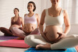 Group of pregnant women practicing yoga in gym, closeup