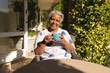 © wavebreak3 - Portrait of smiling senior african american woman having tea in sunny garden