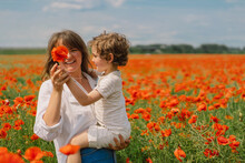 Happy Mother's Day. Little Boy And Mother Is Playing In A Beautiful Field Of Red Poppies
