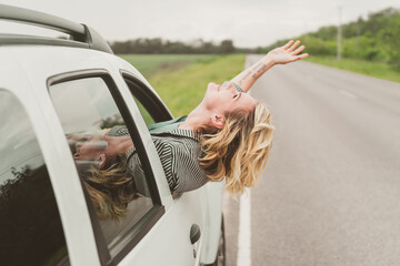 Happy young woman travels by car. Road trip