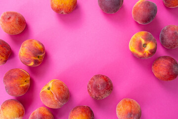 Wall Mural - scattered ripe peaches, lies on a pink background