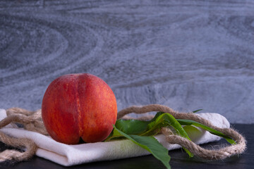 one juicy and ripe peach is on a napkin