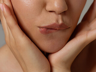 Close-up of sexy female lips with tongue. Clean skin and a clear lip contour are outlined with a fashionable marsala lipstick. White teeth and the beauty of smile for stamotologii, spa or cosmetology