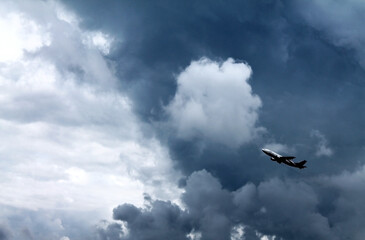 Black and white photo of plane taking off against the background of storm clouds.