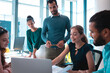© Wavebreak Media - Group of diverse businesspeople discussing together sitting at table and using laptop