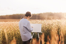 Young Guy Paints On Canvas In Nature In Summer. Artistic Work In Nature. Plein Air.