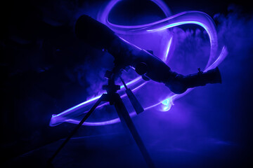 Wall Mural - silhouette of a astronomy telescope on dark foggy backlight.