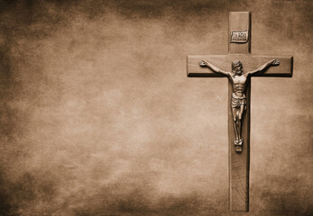 Closeup shot of a Sepia-toned crucifix with the body of Christ on a large background