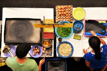 Filipino chef vendor cooking local street food philippine style at hawker shop for sale philippine people and foreign traveler customer eat drink at intramuros square of Maynila in Manila, Philippines