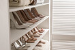 Leinwandbild Motiv Different stylish women's shoes on shelving unit in dressing room