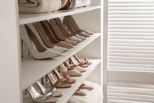 Different Stylish Women's Shoes On Shelving Unit In Dressing Room