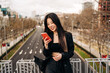 © ADDICTIVE STOCK - Long hair brunette Asian woman using mobile phone in the street