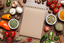 Open Recipe Book And Different Ingredients On Wooden Table, Flat Lay. Space For Text