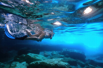 Wall Mural - Underwater photo of female diver in caves in Kleftiko, a beautiful scenic white volcanic rock formation bay with turquoise crystal clear sea often called as the sea Meteora of Greece, Milos island
