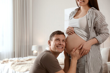 Canvas Print - Young pregnant woman with her husband at home, closeup