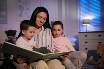 Sticker - Mother reading bedtime story to her children at home