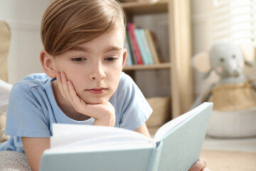 Sticker - Little boy reading book on floor at home