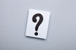 Paper card with question marks on grey background. Pile of question marks, top view