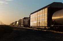 A Freight Train Rolls Off Into The Sunset I The Arizona Desert.
