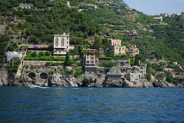 Amalfi coast houses over the rocks view from the boat on a summer day, Salerno, Italy