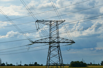 High-voltage electric lines, towers and industrial infrastructure against the blue sky