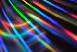 Fototapeta Tęcza - Holographic neon background. Neon rainbow strips on dark background. Soft focus Abstract rainbow color wave strips horizontal background.