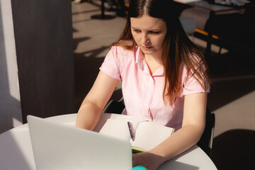 A student does homework on a remote study at a university during a pandemic in a bright workspace